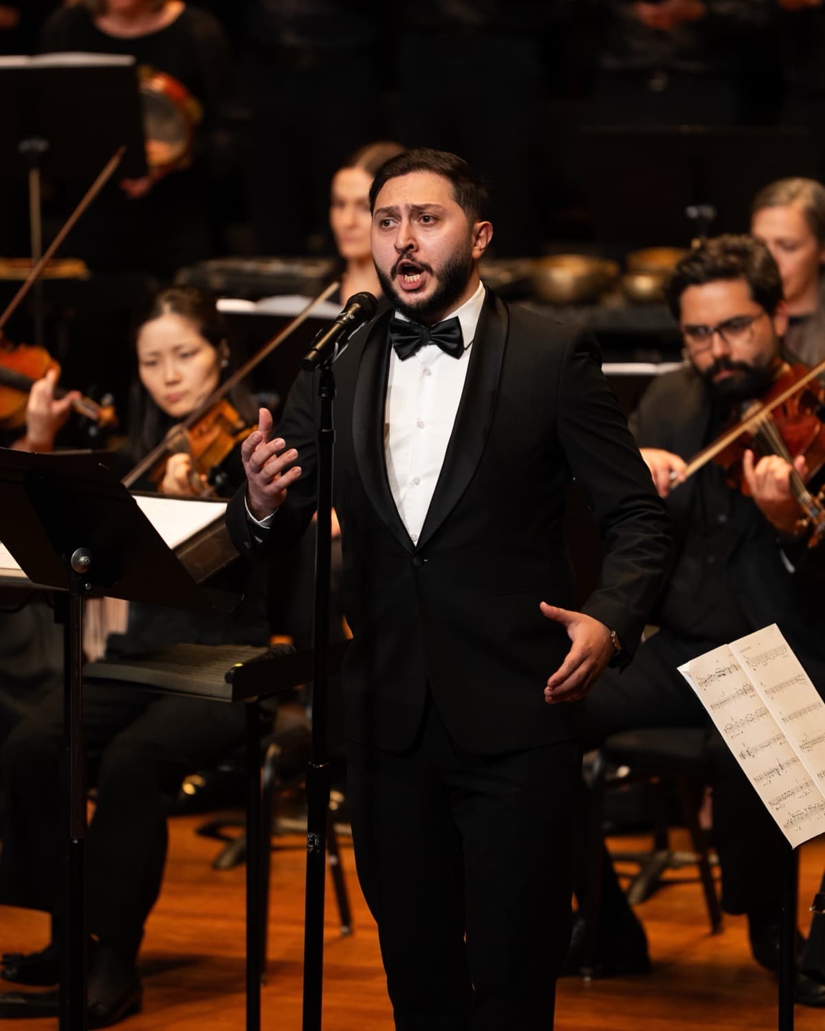 Emin Ismayilov in concert dress, singing with orchestra behind him