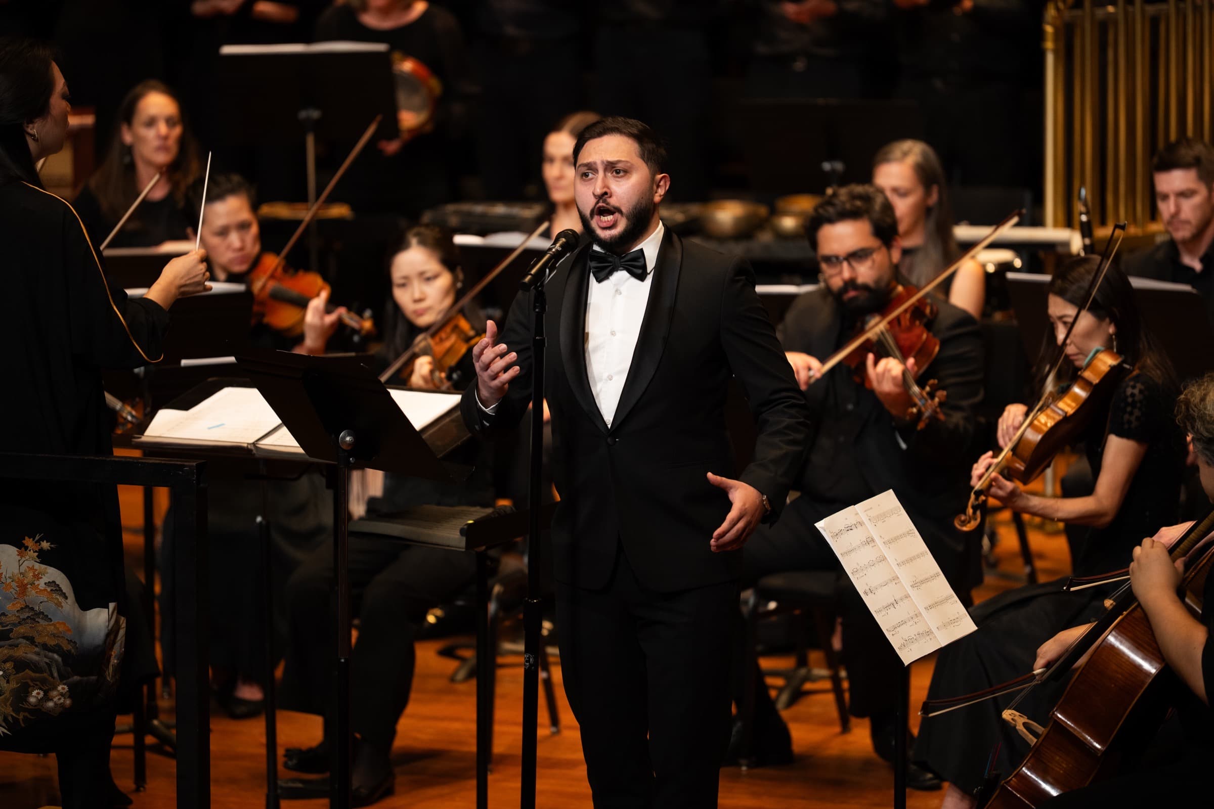 Emin Ismayilov singing as tenor soloist in front of orchestra and chorus at Jordan Hall, Boston